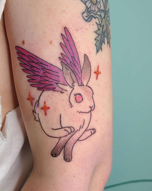 tattoo of a rabbit with purple angel wings.
