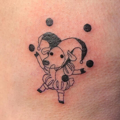 black tattoo of a cartoon style sheep jester juggling balls.