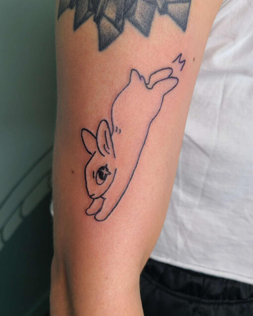 black line tattoo of a cartoon kicking rabbit.